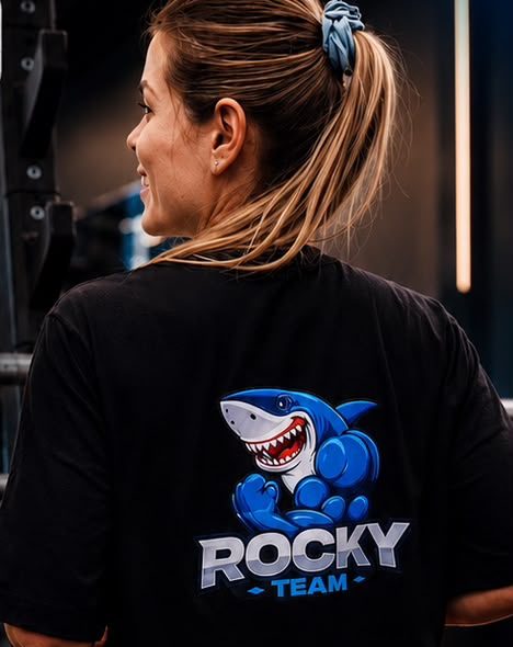 Aluna Rocky Team de costas com a camiseta do tubarão mascote